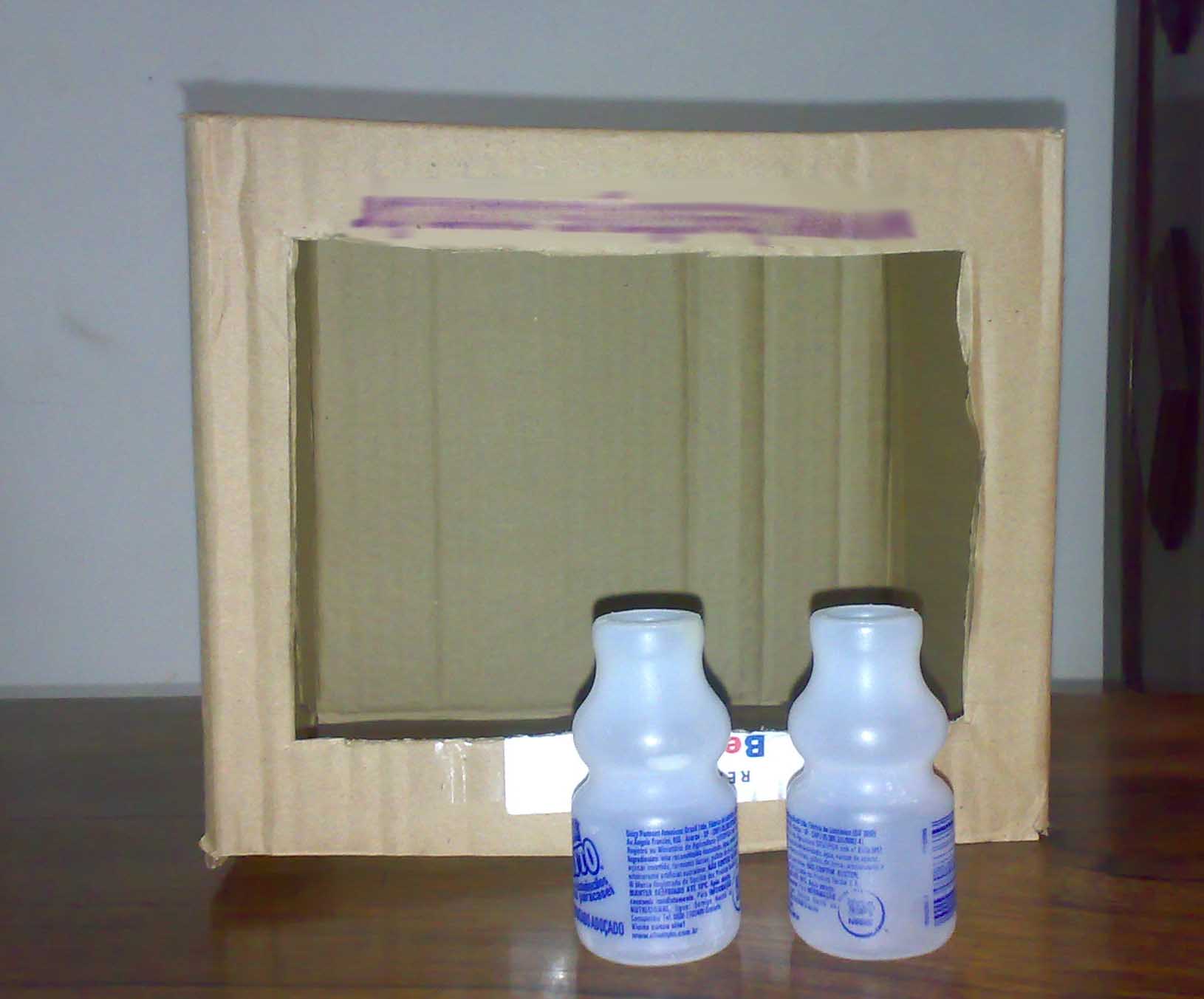 Uma caixa de papelão e duas embalagens de leite fermentado